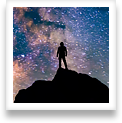 A night hiker looks up at the Milky Way in wonder
